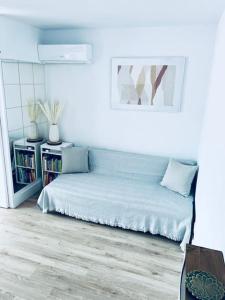 ein weißes Zimmer mit einem Bett und einem Bücherregal in der Unterkunft ROMY Studio à 5 min de la plage in Canet-en-Roussillon