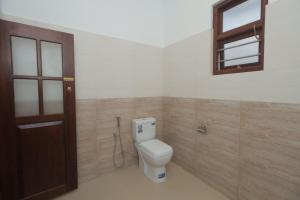 a bathroom with a toilet and a window and a door at Hide Hiriketiya Villa in Dickwella +25 photos