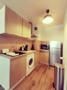 a kitchen with a washing machine and a refrigerator at Appartement charmant parking gratuit in Vaulx-en-Velin