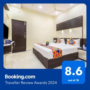 a hotel room with a bed and a television at FabHotel Crown Suites - Nr Sony Signals in Bengaluru