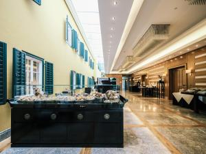 eine große Lobby mit einem Buffet in der Mitte in der Unterkunft Falkensteiner Schlosshotel Velden – The Leading Hotels of the World in Velden am Wörthersee