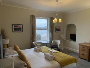 um quarto com uma cama grande e toalhas em The Wildings Hotel & Tudno's Restaurant em Llandudno
