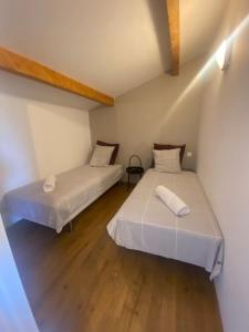 twee bedden in een kleine kamer met houten vloeren bij Appartement 3 chambres à proximité des plages in Cannes