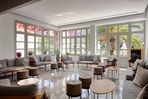 a lobby with couches and tables and windows at Pedi Beach Hotel in Symi