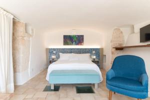 奥斯图尼Hasamami Eco Trullo, Ostuni luxury suite的一间卧室，有一张床和一把蓝色椅子
