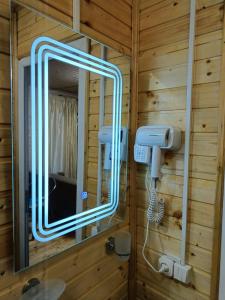 a bathroom with a mirror with a lightedigunigunigun at Kottage anania in Batumi