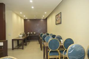 una clase con sillas azules y una pizarra en una habitación en VK Hotels & Resorts en Amritsar