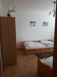 een kamer met 2 bedden en een deur naar een slaapkamer bij Nordstraße 5 - Ferienwohnung für 2 Personen in Neukieritzsch in Neukieritzsch