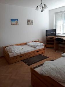 een slaapkamer met 2 aparte bedden en een bureau bij Nordstraße 5 - Ferienwohnung für 2 Personen in Neukieritzsch in Neukieritzsch