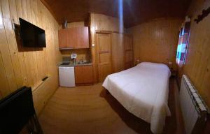 a small bedroom with a bed and a kitchen at Camping Bungalows La Borda del Pubill in Ribera de Cardós