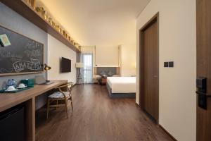 a hotel room with a bed and a desk at M Continental by Mandala Bac Giang in Bắc Giang