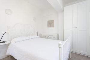a white bedroom with a white bed and a dresser at Home2Book Stylish & Bright Apt, Santa Cruz Center in Santa Cruz de Tenerife