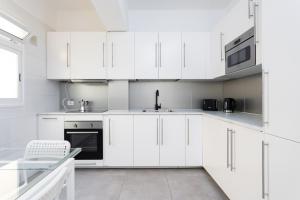 a white kitchen with white cabinets and a sink at Home2Book Stylish & Bright Apt, Santa Cruz Center in Santa Cruz de Tenerife
