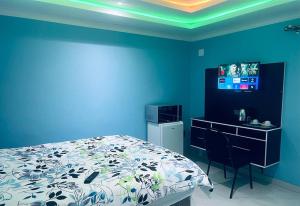 Dormitorio con cama, escritorio y TV en Goldwel Lodge, en Kempton Park