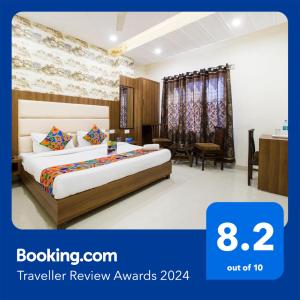 アムリトサルにあるFabHotel Royal Villa Hussainpura Chowkのベッドとデスクが備わるホテルルームです。