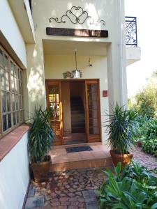 an entrance to a building with two potted plants at Aan die Voet van die Magalies in Pretoria