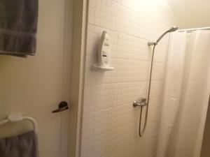 La salle de bains est pourvue d'une douche avec un pommeau de douche. dans l'établissement Chambre indépendante, à Porto Novo