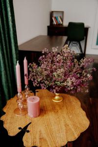 una mesa con un jarrón de flores y dos velas en Hotel Thethi, en Theth