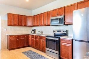 a kitchen with wooden cabinets and stainless steel appliances at Charming Guest House near Chalk Sound and the Beach in Providenciales