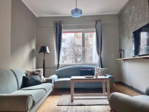 a living room with a couch and a table at Eternity Apartment: Award-Winning Design in the Heart of the City Center in Sofia