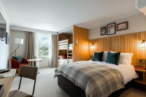 a bedroom with a bed and a desk and a chair at The Park Hotel in Teddington