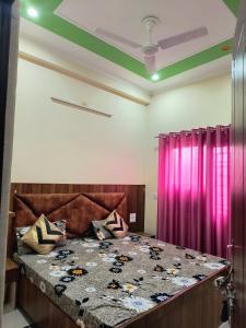 - une chambre avec un lit et un rideau pourpre dans l'établissement SHREE JI HOMESTAY, à Rishikesh