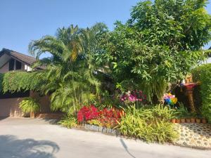 a garden of flowers and trees in front of a house at Ratchawong Place ราชวงศ์ เพลส --หลังพ่อขุน-- in Phayao +5 photos