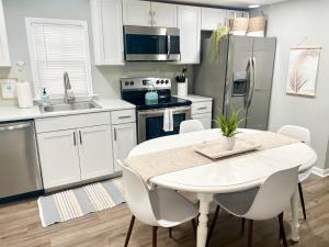 cocina con mesa blanca y electrodomésticos blancos en Pet- & kid-equipped 2 br cottage near downtown, en Charleston