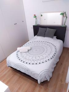 1 dormitorio con 1 cama grande con sábanas blancas en Casa con jardín, en Almería