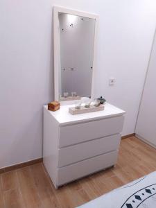 y baño con lavabo blanco y espejo. en Casa con jardín, en Almería