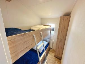 a small room with a bunk bed and a ladder at Chalet 5a op Recreatiepark De Wielen in Sint Maarten +24 photos