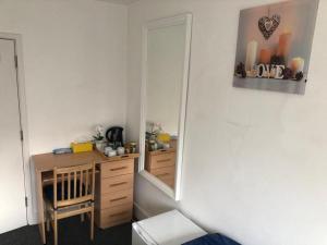 Habitación con escritorio y espejo. en Cosmopolitan Comfort Private Bedrooms in Euston 106, en Londres