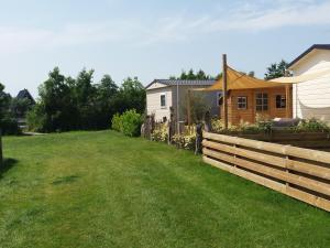 a yard with a fence and a house at Chalet 5a op Recreatiepark De Wielen in Sint Maarten