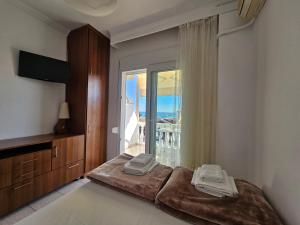 a bedroom with a bed and a large window at Leonidas Apartments in Nea Peramos