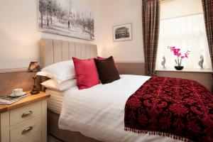 a bedroom with a red and white bed and a window at Bank View in Melrose
