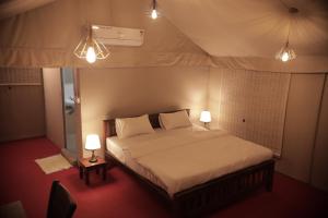a bedroom with a bed in a tent with two lamps at Anamala Serenity Homestay Kerala in Lakkidi