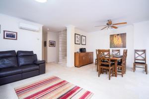 a living room with a couch and a table and chairs at Jardines de Niza in Jávea