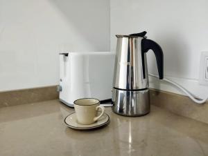eine Kaffeekanne und eine Tasse auf der Theke in der Unterkunft Piso vacacional acogedor in A Coruña