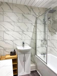 a bathroom with a sink and a shower and a tub at 3 Bedroom House in York