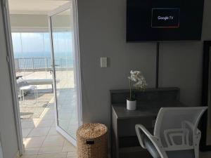 a living room with a table and a view of the ocean at A quintessential work-relax space in La Mercy