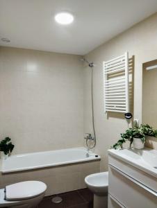 ein Badezimmer mit einer Badewanne, einem WC und einem Waschbecken in der Unterkunft Piso vacacional acogedor in A Coruña