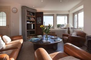 a living room with a couch and a table at La Villa de Pascal, vue mer in Penmarch