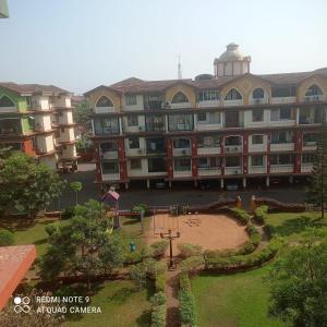 a large building with a park in front of it at 2 bhk dream resort porvorim in Old Goa
