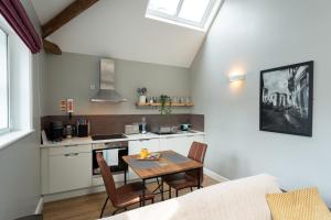 a kitchen and living room with a table and chairs at High Street Town House in Manchester