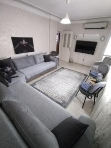 a living room with a couch and a tv at Ege Üniversitesine ve Hastane ye çok yakın aile için uygun in Burunabat