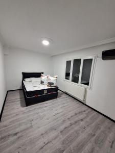 biały pokój z łóżkiem i 2 oknami w obiekcie Ege Üniversitesine ve Hastane ye çok yakın aile için uygun w mieście Burunabat