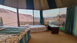 ein Zimmer mit zwei Betten und Blick auf die Wüste in der Unterkunft Rum Gonesh Luxury Camp in Wadi Rum