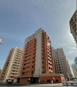a tall apartment building in the middle of a city at Nahda Star Residence - Home Stay in Dubai