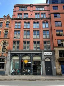 a large brick building with a store in front of it at High Street Town House in Manchester