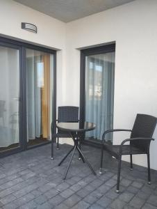 a patio with two chairs and a table and chairs at Apartament Sunset Leszno in Leszno